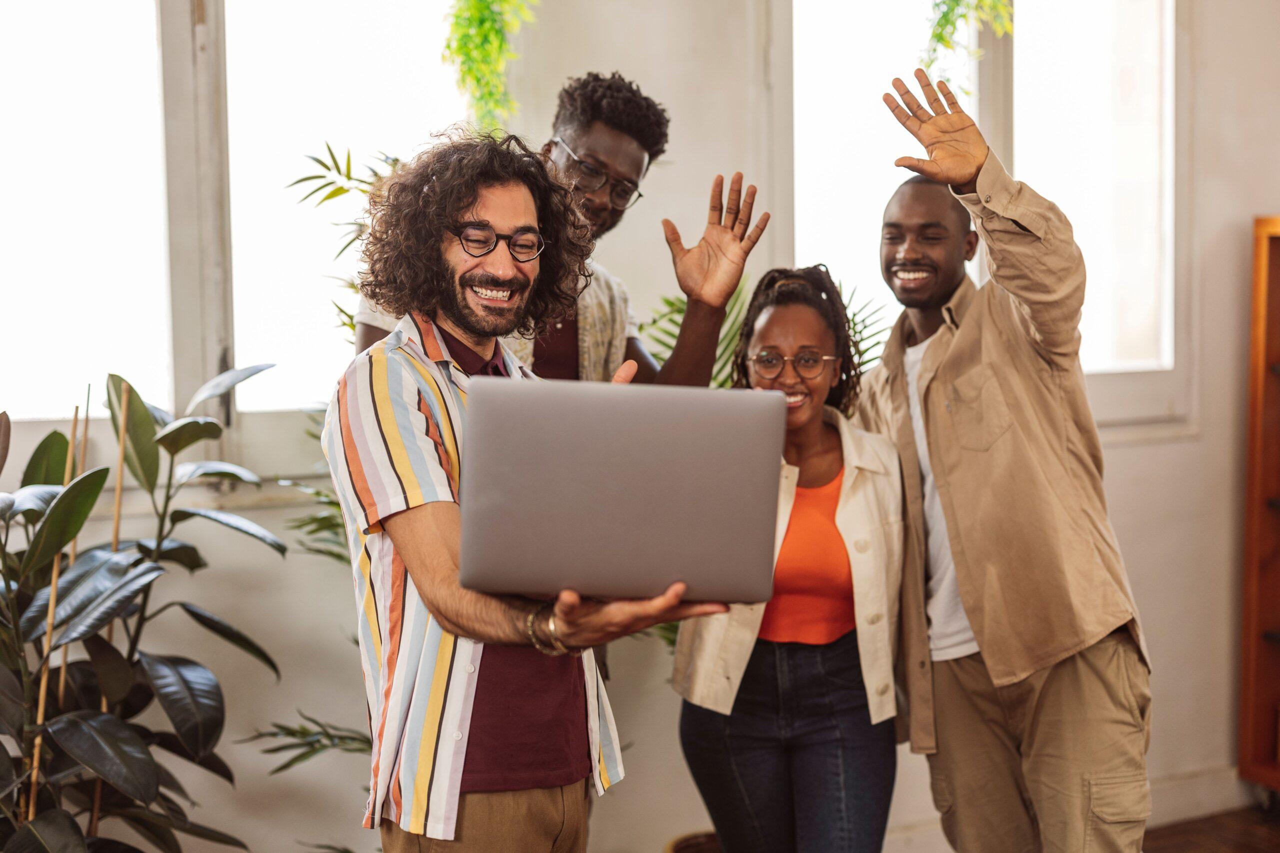 Happy diverse team waving during a video call, symbolizing strong collaboration and human-centered success in OnlyFans agency hiring